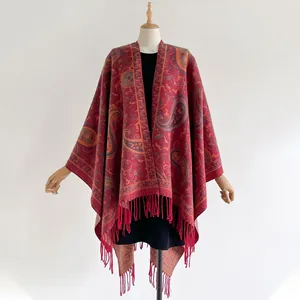 Detail of red Paisley ethnic shawl featuring intricate woven patterns and long tassels