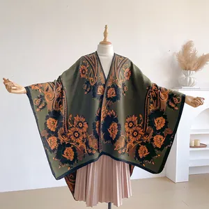 Nahaufnahme des Boho-Blumen-Jacquards auf einem klassischen grünen Strickponcho für Damen
