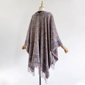 Vista detallada del estampado jacquard paisley y flecos en un elegante chal pashmina