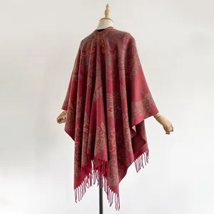 Détail du motif paisley ethnique et de la bordure à franges sur le châle tissé rouge