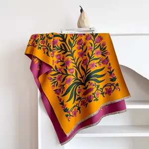 Detail of double-sided floral cashmere scarf with fringed edges in yellow and purple