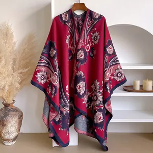 Detailansicht der Retro-Blumenmuster und feinen Nähte auf dem dicken roten Poncho