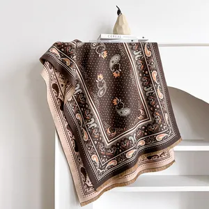 Makro-Detail von braun-beigem Paisley-Schal mit weichen Fransen am Rand