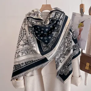 Détail d'une écharpe bicolore noire et blanche à motifs cachemire avec franges