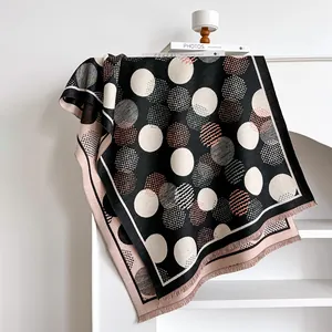 Close-up of geometric polka dot cashmere-like scarf with fringe details and woven texture