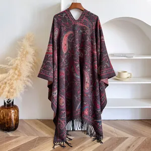 Macro detail of Bohemian paisley jacquard shawl with decorative black fringe hem