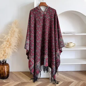 Detail of burgundy ethnic jacquard shawl with floral patterns and black fringe tassels