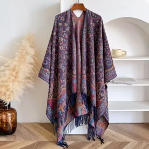 Detalle del chal de jacquard paisley con flecos azules colgado en una percha de madera