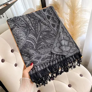 Châle vintage en jacquard à motifs cachemire avec franges noires sur chaise beige
