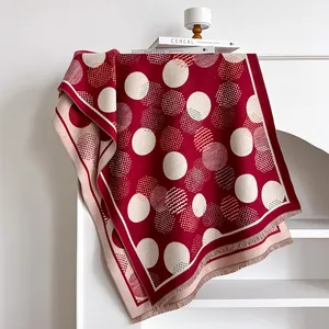 Detail of red and cream polka dot scarf with cashmere-like texture and fringed edges