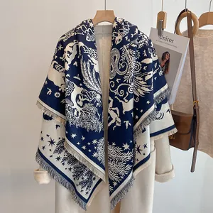 Détail du châle pashmina bleu marine et crème avec imprimé mythique et franges sur manteau