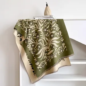 Detail of floral tree jacquard pattern on olive green and cream cashmere-feel scarf