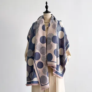 Close-up of geometric polka dot cashmere-like scarf with fringe details in blue and pink