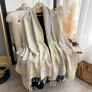 Dettaglio della morbida sciarpa jacquard con motivi paisley floreali e frange bianche