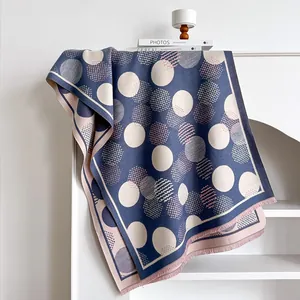 Detailed texture of geometric polka dot scarf with fringes on a minimalist rack
