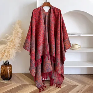 Close-up of ethnic red paisley jacquard shawl with thick fringe tassels on wooden hanger