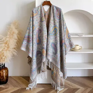Detail of paisley pattern knit shawl with elegant white tassels and ethnic embroidery