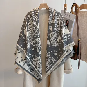 Détail d'un châle imprimé vintage au toucher cachemire avec motifs et pompons