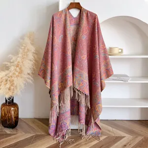 Detail van etnische jacquard sjaal met paisley-patroon en franjes aan een houten hanger