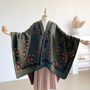Close-up of olive green cashmere shawl with orange floral pattern and stitched edges