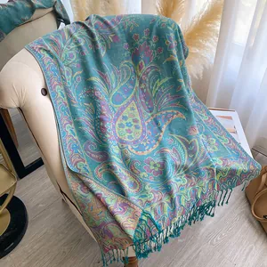 Detail of teal paisley pashmina shawl featuring colorful floral jacquard and long tassels