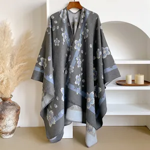 Close-up of grey knit shawl featuring light blue cherry blossom prints and edge stitching