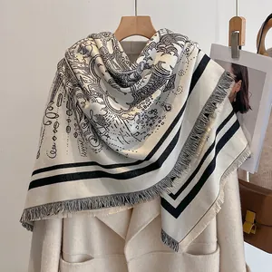 Détail d'une écharpe crème style cachemire avec lignes abstraites et bords à franges