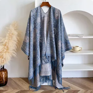 Detail view of ethnic paisley jacquard pattern and long tassel hem on soft blue shawl