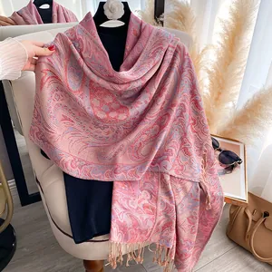 Close-up of pink paisley floral scarf featuring soft cashmere texture and tassel fringe