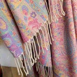 Detail view of ethnic paisley jacquard pattern and soft cream tassels on pashmina