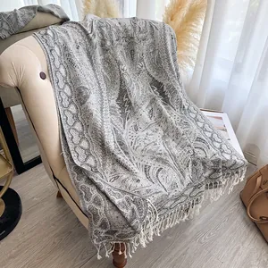 Gros plan sur le motif cachemire gris et blanc du châle pashmina avec des franges