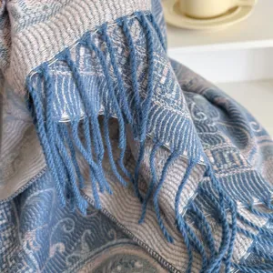 Macro detail of blue-grey cashmere shawl showing paisley weave pattern and fringe