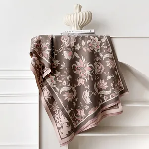 Detailed view of floral jacquard patterns and short tassels on a thick cashmere-like shawl