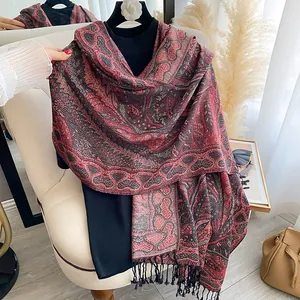 Détail d'un châle vintage à motif paisley, jacquard ethnique rouge et noir à franges