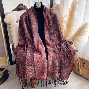 Detail of red and black paisley pattern scarf featuring elegant long tassels on edges