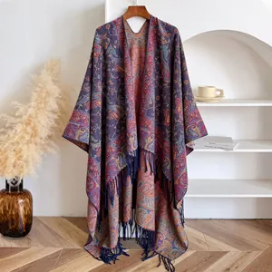 Detail van bordeauxrode paisley jacquard sjaal met blauwe franjes aan een houten hanger