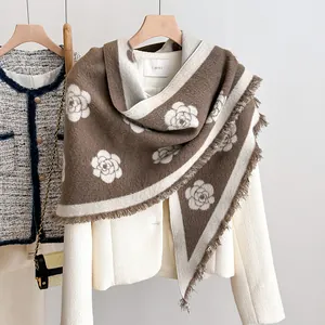 Detail of brown and white camellia pattern shawl with fringe edges and thick texture