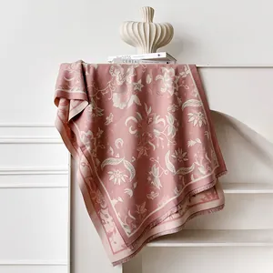 Detailed view of floral jacquard texture and fringes on pink cashmere-like shawl