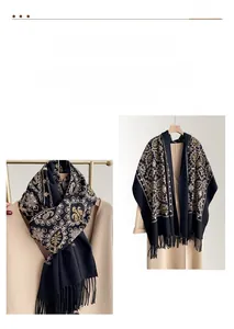 Close-up of golden paisley embroidery and long black tassels on a cashmere-like scarf