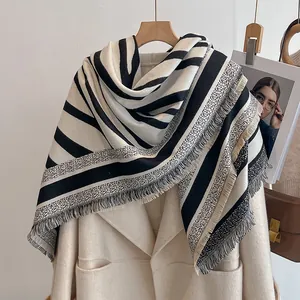 Détail d'une écharpe rayée noir et blanc avec de longues franges et motifs à pois