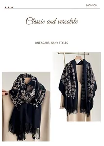Close-up of floral embroidery on black cashmere-like scarf with fringe details