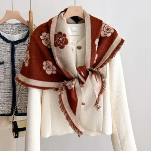 Detail of camellia flower patterned shawl scarf with frayed edges in caramel and cream