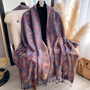 Close-up of intricate paisley jacquard pattern with fringe detail on a long shawl scarf