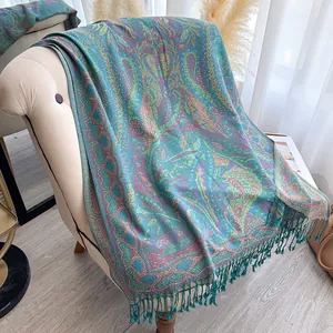 Détail du motif jacquard paisley avec franges sur un châle pashmina bleu lac soyeux