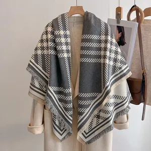 Détail d'une écharpe pied-de-poule gris et beige avec finitions à franges douces