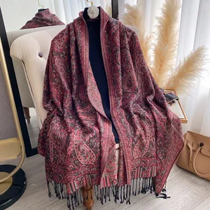 Detail van paisley sjaal met zwarte franjes en zachte kasjmierachtige textuur luxe