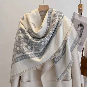 Nahaufnahme von beigem Pashmina-Schal mit grauem Paisle Paisley-Muster und Fransen-Details