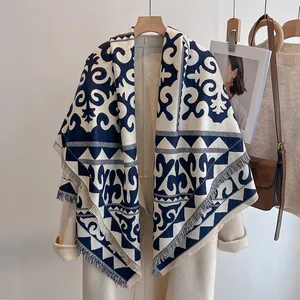 Détail d'un châle vintage bleu foncé à motifs géométriques avec des franges