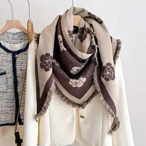 Detail of beige and coffee floral knit shawl with soft tassel edges for autumn wear