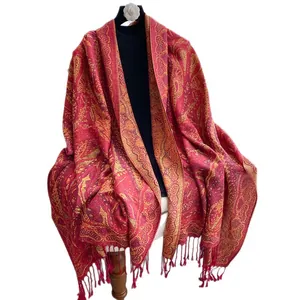 Châle rouge rétro avec motifs cachemire dorés et franges sur un mannequin noir élégant